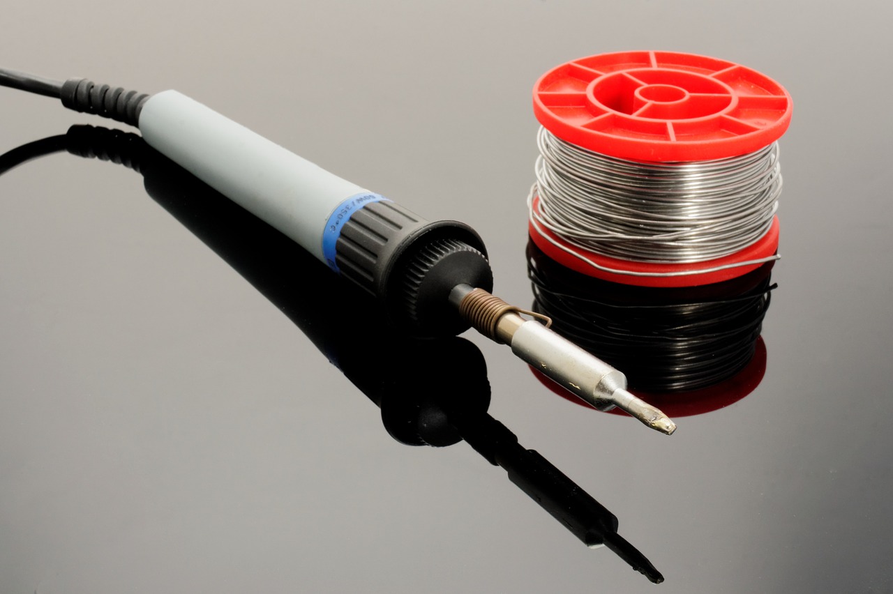 grey soldering iron and solder