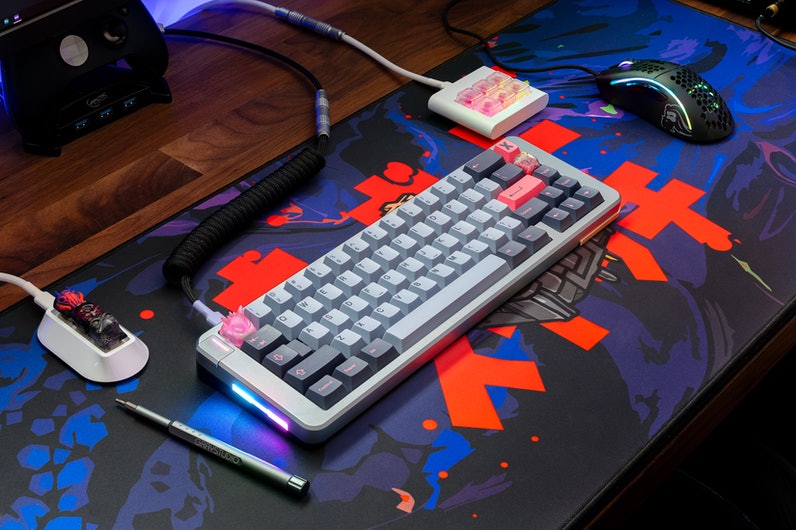 grey keyboard with grey and dark blue keycaps on a mousepad